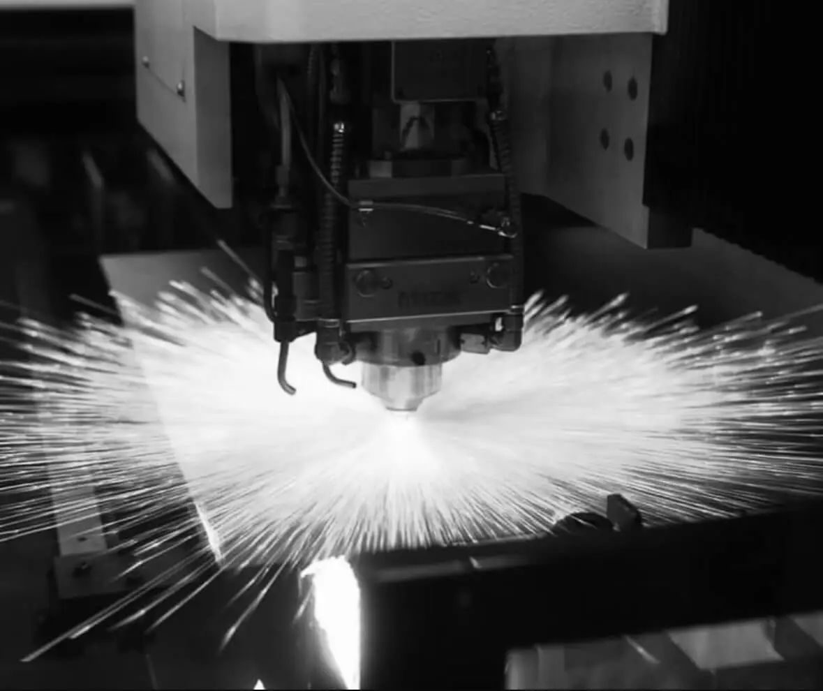 Mazak fibre laser cutting head cutting sheet metal with sparks spraying across the bed